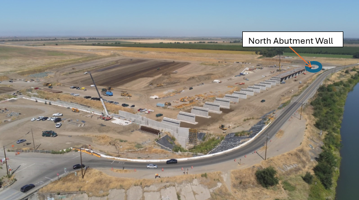 image shows a series of bridge piers lined up along a river with a blue circle on the far right of the image labeled as "North Abutment Wall."